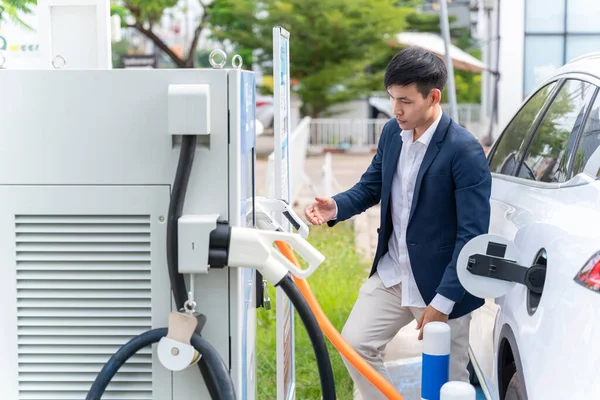 Een Man Die Een Stroomkabel Aan Een Elektrische Auto Koppelt — Stockfoto