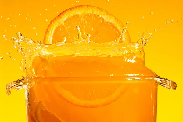 Tranche d'orange tombant dans le liquide — Photo