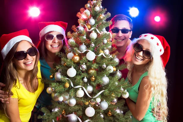 Glückliche Menschen rund um den Weihnachtsbaum — Stockfoto