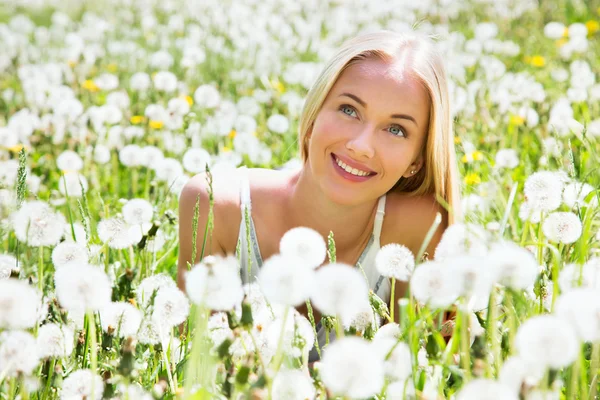 Woman among dandelions — Stock Photo, Image