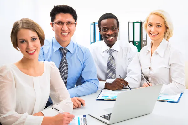 Gelukkige zakenmensen verzameld rond laptop — Stockfoto