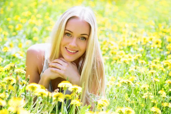 Beautiful young woman among the flowers — Stock Photo, Image