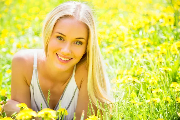 Hermosa joven entre las flores — Foto de Stock