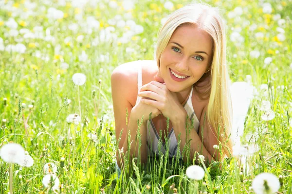 Woman among dandelions — Stock Photo, Image