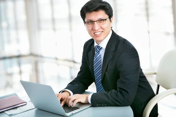 Smiling businessman with laptop — Stock Photo, Image