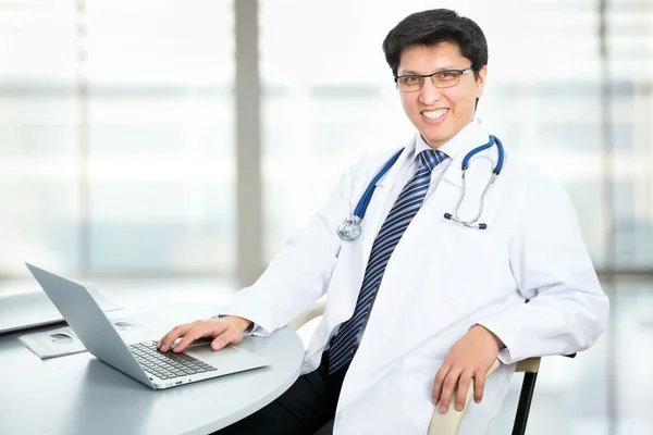 Médico sonriente posando con portátil — Foto de Stock