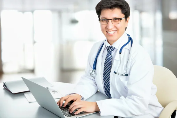 Médico sonriente trabajando con portátil — Foto de Stock