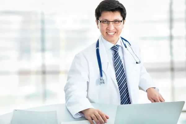 Médico sonriente trabajando con portátil — Foto de Stock