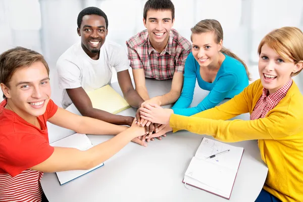 Students showing unity with their hands together — Stock Photo, Image