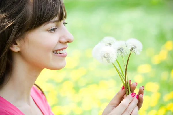 Happy girl admiring dandelions — Stock Photo, Image