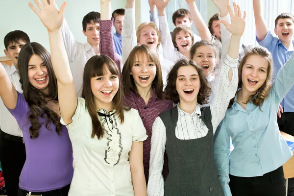 Students with hands raised — Stock Photo, Image