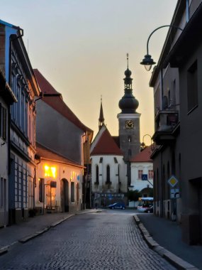 Akşam vakti. Avrupa 'da boş sokak yolu ve eski binalar, arka planda arabalar ve otobüs