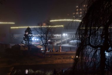 Küçük Avrupa kasabası geceleri sis ve aydınlatma ışıklarıyla 