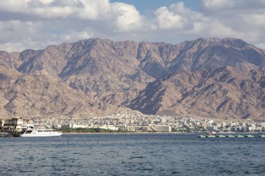 boats in water, desert hills and Eilat Aqaba gulf at Red sea, southern Israeli port 