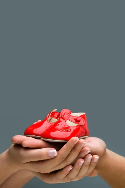 Woman and her husband holding baby shoes in their hands. — Stock Photo, Image