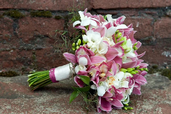 Boeket van orchideeën, rozen, irissen en andere bloemen op een natuurlijke achtergrond. — Stockfoto