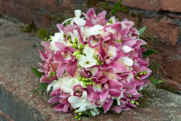 Bukett från orkidéer, rosor, Iris och andra blommor på en naturlig bakgrund. — Stockfoto