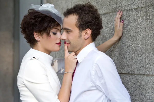 Stylish bride passionately presses the groom against the wall. — Stock Photo, Image