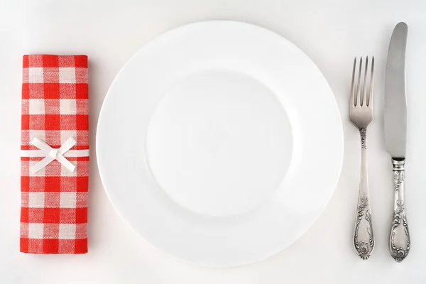 Ensemble de couverts vintage avec fourchette, couteau, assiette et serviette à carreaux rouges. Vue aérienne . — Photo