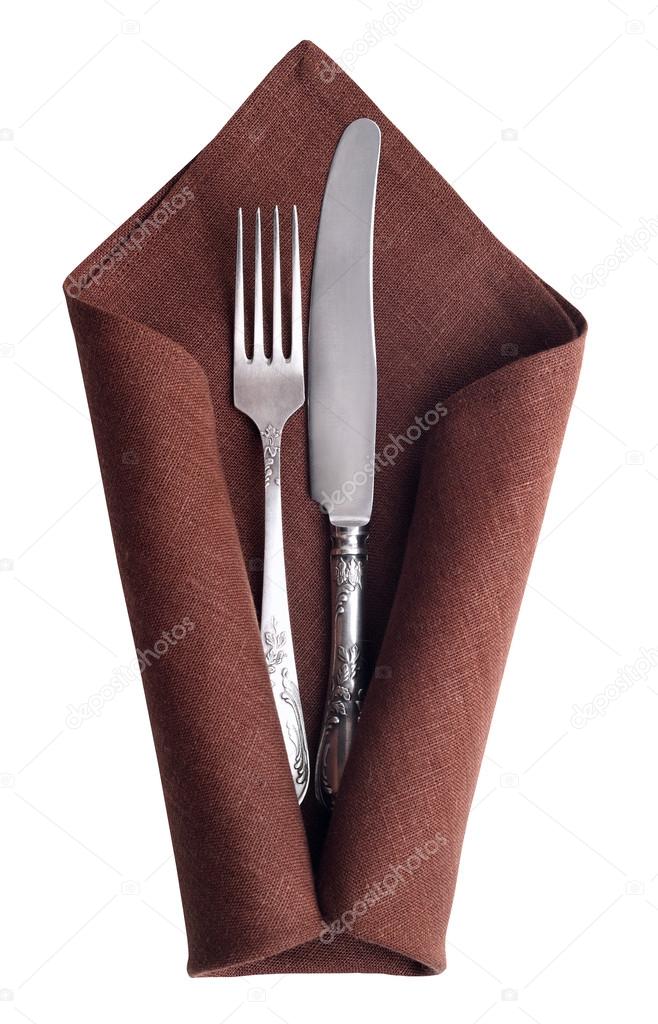 Vintage knife and fork at napkin isolated on white background.