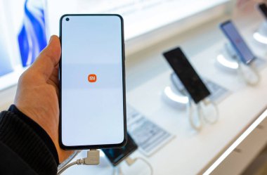 Elinde Xiaomi logosu olan akıllı telefon. Müşteri akıllı telefonu cep telefonu dükkanından seçiyor. Minsk, Belarus - 16 Şubat 2022