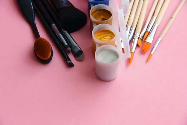 makeup brushes and paint brushes for drawing and painting on a light background