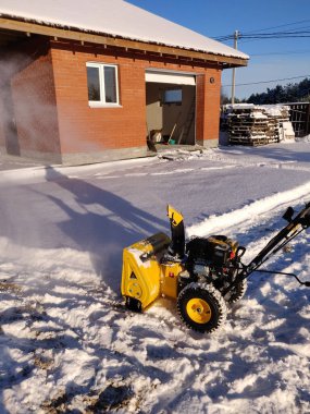 Kışın kar fırtınası ile bahçeyi temizlemek, mevsimsel faaliyet.