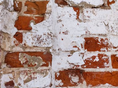 Arka planı alçıdan yapılmış eski tuğlalardan oluşan bir duvar.
