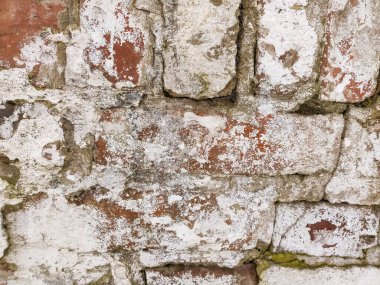 Arka planı alçıdan yapılmış eski tuğlalardan oluşan bir duvar.
