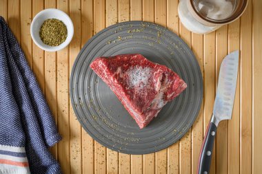 Arka planda bambu paspası olan bir tabak Wagyu bifteği.