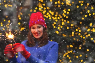 Neşeli esmer kadın kar yağarken sokağın ortasında parlak ışıklarla eğleniyor. Metin için boşluk