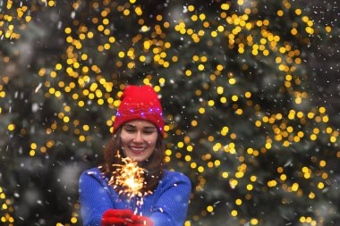Mutlu esmer kadın kar yağarken sokağın ortasında ışıldayan ışıklarla eğleniyor. Metin için boşluk