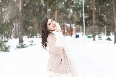 Kışın kar yağarken ormanda yürüyen esmer bir kadın. Metin için boşluk