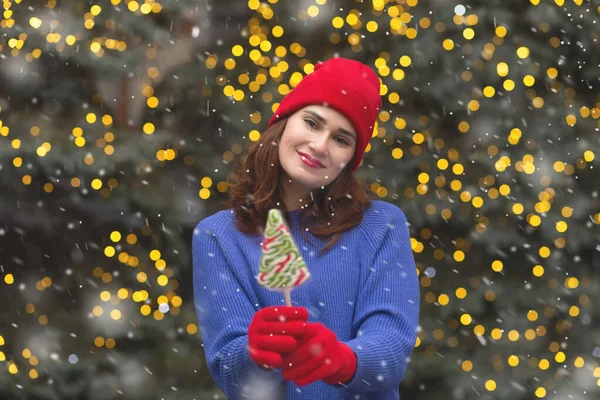 Kar yağarken Noel ağacında şekerli mutlu esmer kadın