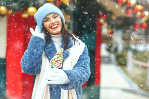 Gorgeous Smiling Woman Holding Candy Christmas Market Snowfall Emprt Space — Stock Photo, Image