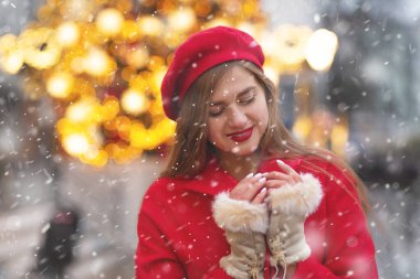 Kar yağışı sırasında sokak fuarında yürüyen kırmızı ceketli harika bir genç kadın. Boş boşluk