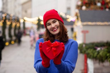 Neşeli genç bayan Noel panayırında bir kutuda hediye alıyor.