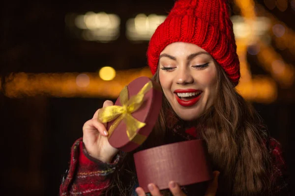 Excited Young Woman Red Hat Opening Gift Box Christmas Fair — Stock Photo, Image