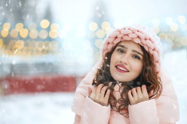 Yeni yıl fuarında yürüyen büyüleyici gülümseyen kadının açık hava kış portresi. Metin için boşluk