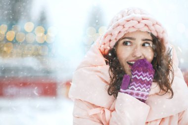 Bayram panayırında kar yağışı seyreden heyecanlı genç bir kadın. Metin için boşluk
