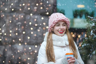 Neşeli kadın, kar yağışının tadını çıkararak kahve içiyor. Metin için boşluk