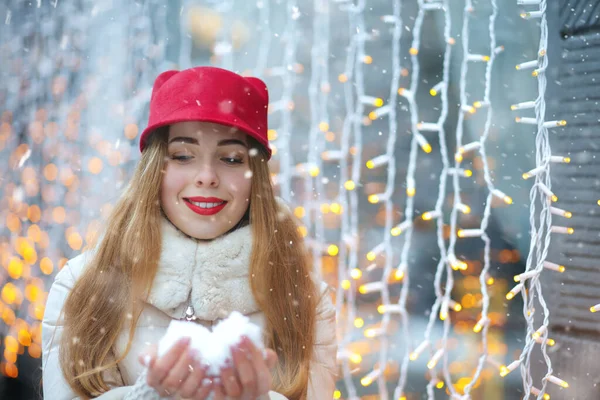 美丽的微笑的女人在她的手中拿着雪在花环的背景 案文的篇幅 — 图库照片