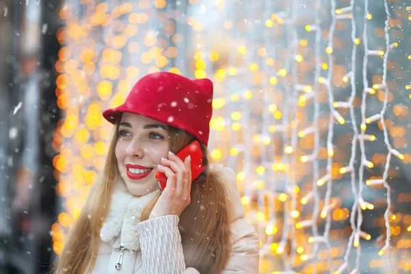 下雪天 一个红唇的快乐女人在手机上聊天 案文的篇幅 — 图库照片