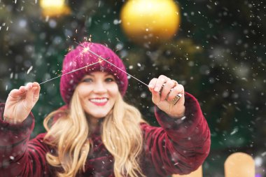 Kış tatilinde Central City Meydanı 'nda maytaplarla oynayan hoş bir genç kadın. Metin için boşluk