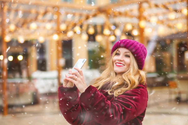漂亮的年轻女子在街上的冬日市场拍照 — 图库照片