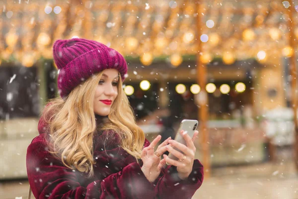 Güzel Gülümseyen Genç Bir Kadın Kış Pazarında Akıllı Telefonuna Mesaj — Stok fotoğraf