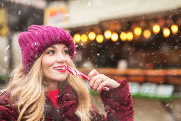 Merry Blond Woman Wears Knitted Hat Eating Sweet Candy Cane — Stock Photo, Image
