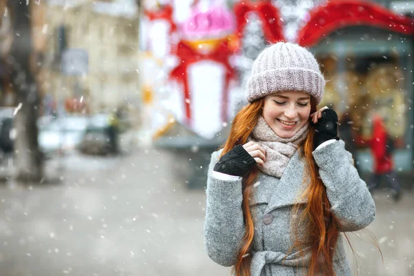 降雪时 红头发的快乐女人穿着外套在城里散步 案文的篇幅 — 图库照片