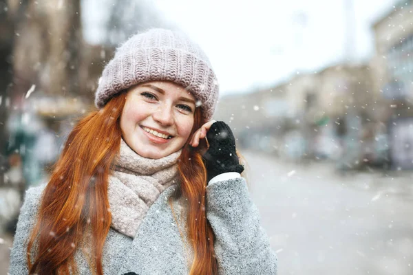 面白い赤い髪の女性は雪の中で街を歩くコートを着ています テキストのスペース — ストック写真