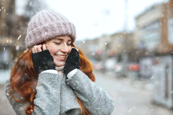 大雪下的时候 漂亮的红头发女人穿着外套在城里散步 案文的篇幅 — 图库照片